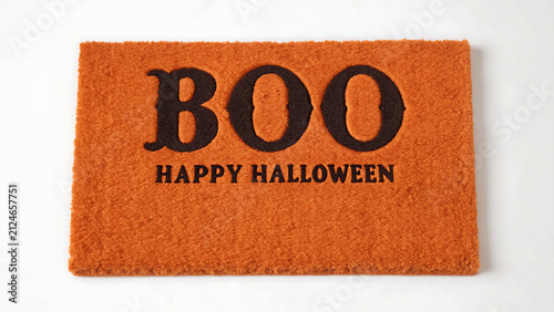 Halloween doormat with spooky greeting for festive home decor. Orange welcome mat featuring bold BOO text and seasonal holiday message.