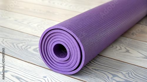 Rolled purple yoga mat on wooden floor ready for workout. Fitness exercise equipment for home gym or studio practice.