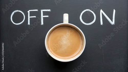 Coffee cup with on off chalkboard concept. Morning latte or cappuccino next to handwritten power switch for productivity and energy.