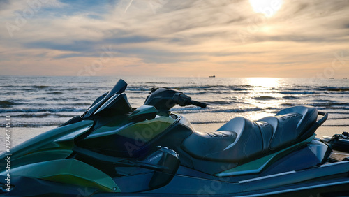 Foto Modern jet ski parked on a sandy beach against the sea with bright sunset sky