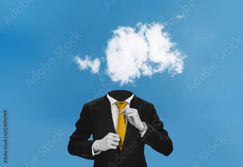 Digital collage, Businessman in black suit with white clouds head on blue sky