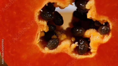 Close-up of ripe papaya flesh and glossy black seeds, showcasing the vibrant orange color and natural texture of this tropical fruit. Rich in vitamins, antioxidants, and dietary fiber, the image is id
