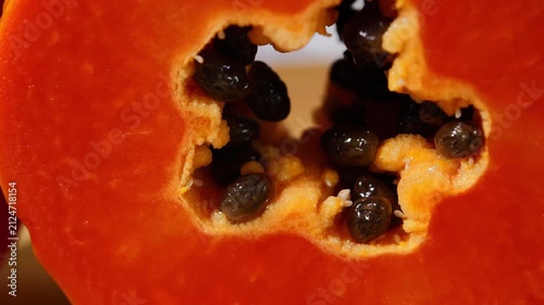 Close-up of ripe papaya flesh and glossy black seeds, showcasing the vibrant orange color and natural texture of this tropical fruit. Rich in vitamins, antioxidants, and dietary fiber, the image is id