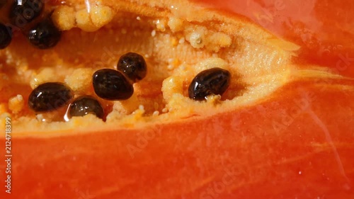 Close-up of ripe papaya flesh and glossy black seeds, showcasing the vibrant orange color and natural texture of this tropical fruit. Rich in vitamins, antioxidants, and dietary fiber, the image is id