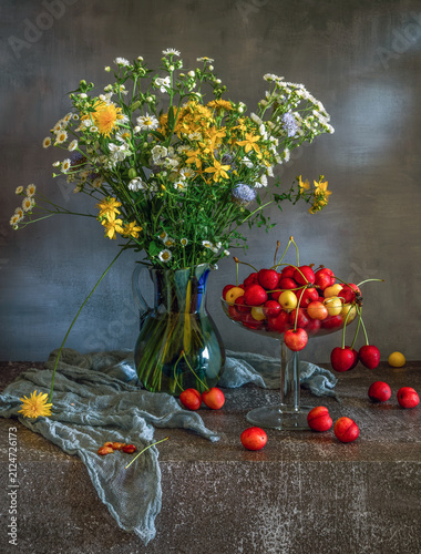 Ripe and delicious cherries straight from the tree and a bouquet of meadow flowers.