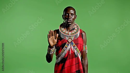 Maasai Man In Traditional Shuka With Beaded Accessories Standing Against Green Background