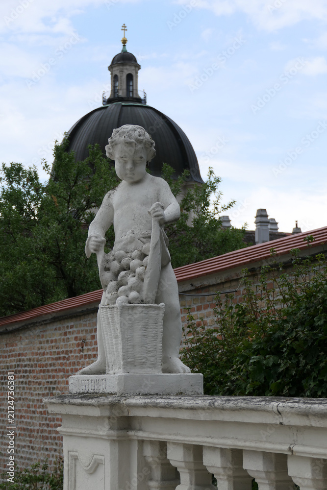 Fototapeta premium Baroque Putto Statue with Grape Basket in the Gardens of Belvedere Palace, Vienna. 