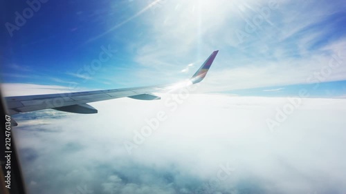 Wing of plane with blue sky and clouds