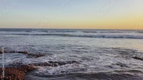 Ocean Waves Gently Washing Over Rocky Beach at Sunset