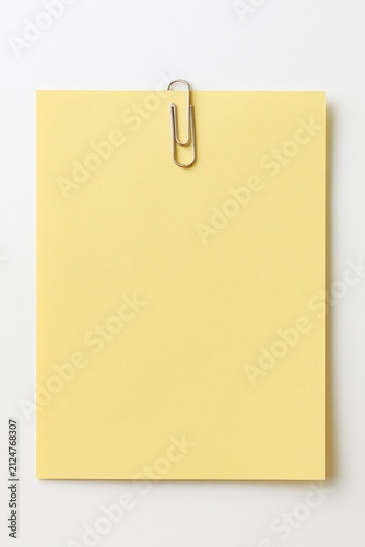 Yellow note held by a silver paperclip
