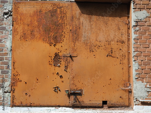 Orange metal door covered in rust