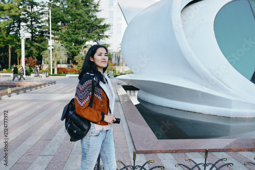 Fashion, woman, backpack in outdoor urban setting near contemporary architecture, showcasing casual style and travel vibe with street photography and modern city ambience