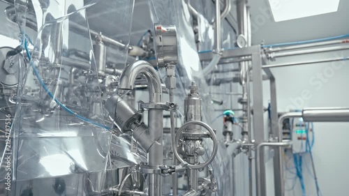 Production facility, shining metal machinery is hard at work. Pipes, valves, and gauges. Technology and automation. Factory machine at work. 4K, UHD