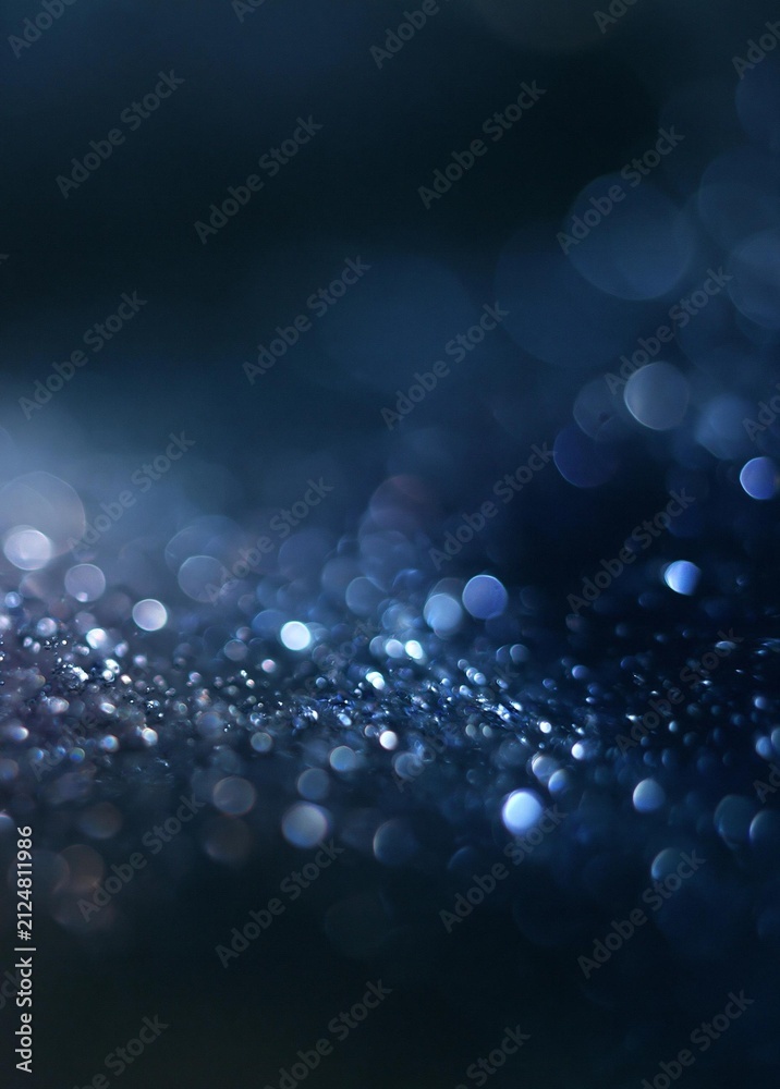 Fototapeta premium Abstract background with a dark blue color. the background is filled with small, circular lights that are blurred and appear to be floating in the air.
