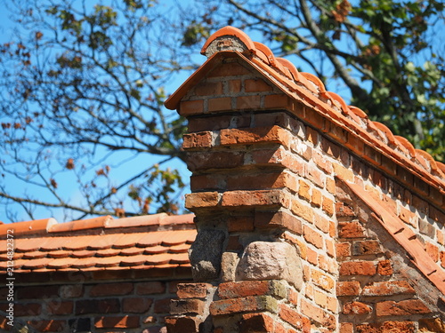 Red brick wall and triangular roof tiles