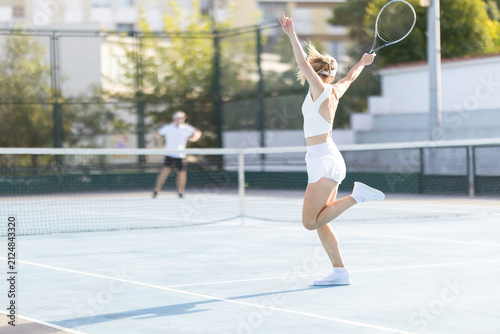 Tennis players practice on a sunny day at an outdoor court in a city