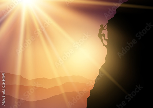Silhouette of a free solo rock climber climbing a mountain against a sunset landscape 