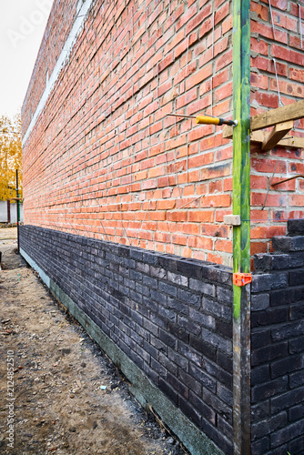 Obraz na płótnie Low-angle perspective view of a long exterior wall under construction, featuring