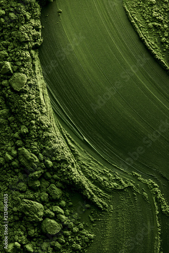 Matcha powder brushed on a green background. Ideal for backgrounds and advertising.