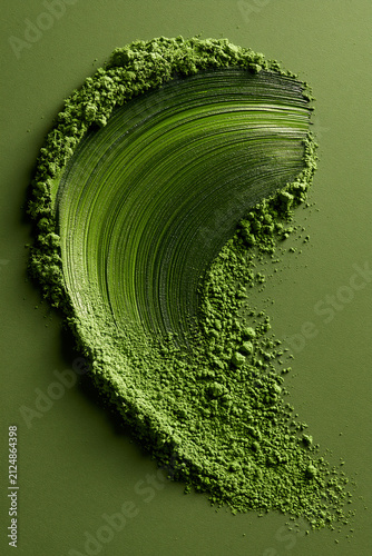 Matcha powder brushed on a green background. Ideal for backgrounds and advertising.