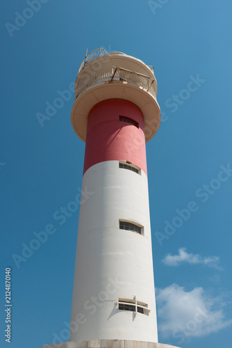 Foto Lighthouse guiding ships with beacon light against blue sky