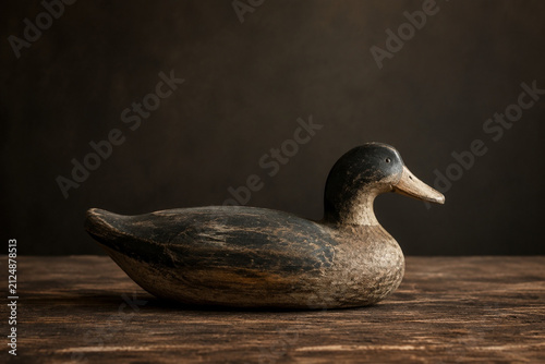Weathered wooden duck decoy on barnwood table, rustic decor and wildlife concept