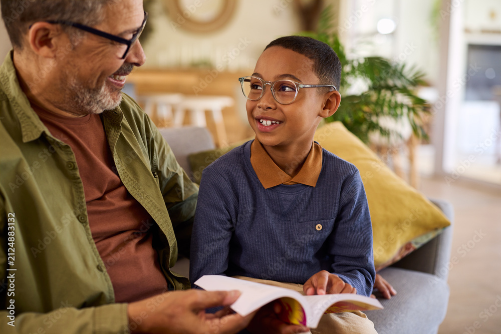 Fototapeta premium Black cute little boy looking his grandfather while learns to read