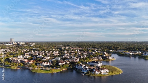 Aerial view of large mansion houses with swimming pool, in affluent neighborhood by Woodlands lake, Houston, Texas, expensive suburban homes surrounding by lush green trees, USA