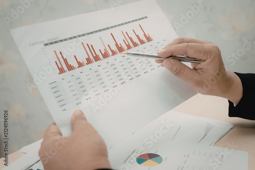 Photography Business professional holding document with financial charts and analytics repor