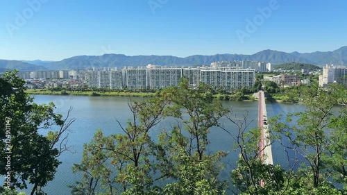 Beautiful aerial view capturing the cityscape of of Chuncheon with Soyanggang river view and the bridge. Mountains, big road and residential apartments buildings and beautiful green hills from afar