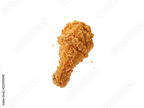 A perfectly golden fried chicken drumstick is captured mid-air, showcasing its crispy texture. The crunchy coating and visible seasoning make it look irresistibly delicious.
