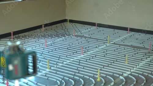 Laser leveling tool working on underfloor heating system installation