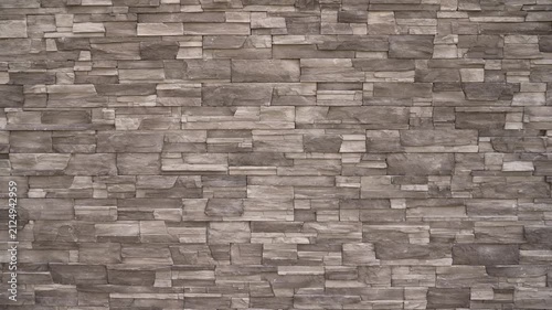 Closeup of stacked stone wall featuring layered rectangular stones in muted gray brown tones. Natural texture subtle lighting create depth