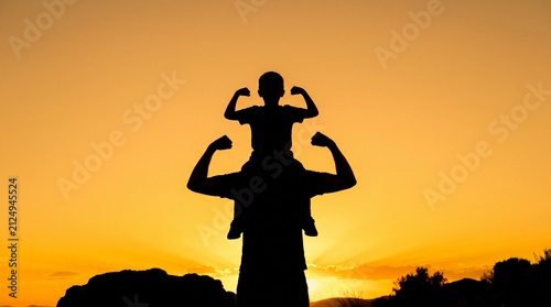 Silhouette of strong father carrying son on shoulders flexing muscles during golden hour sunset sky