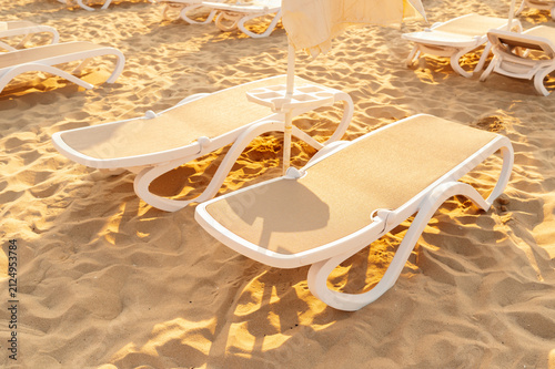beach lounge chairs stationary on sandy beach with relaxed and serene atmosphere top-down view webb.