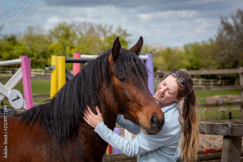Woman Embracing a Bay Connemara Pony in an Outdoor Arena
