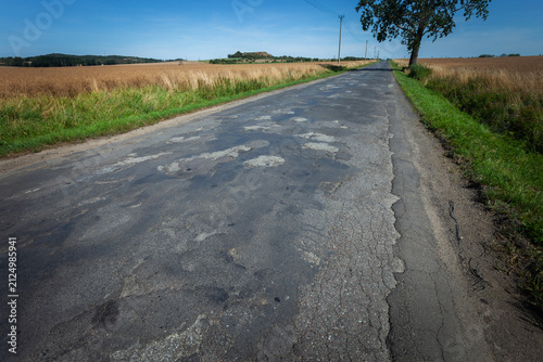 Old asphalt road and patched holes