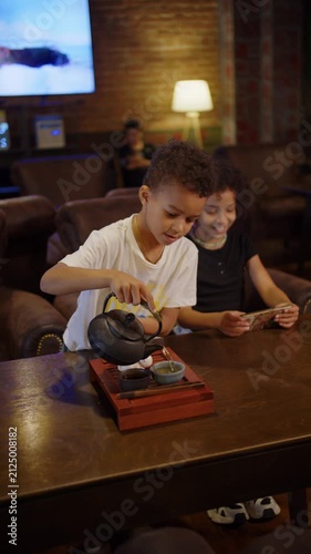 Young boy pouring tea during traditional tea ceremony