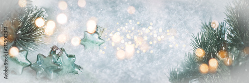 Wonderful winter background image with frosted pine branches. Poinsettias with festive golden bokeh lights in snow. Perfect for christmas greeting card.