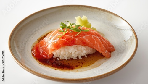Salmon Sushi Slice on Rice Garnished with Onion Greens and Wasabi on a Plate