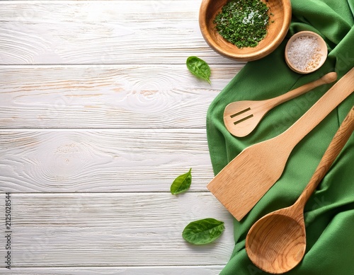 white wooden table covered with green tablecloth and cooking utensils top view