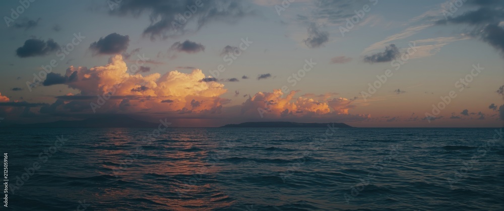 Fototapeta premium Calm Ocean Waters Reflecting Sunset Clouds at Dusk