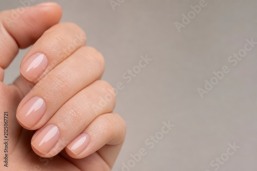 Close Up of Well Groomed Hand with Neatly Manicured Nails on Soft Gray Background