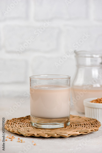 Homemade dairy-free buckwheat beverage with raw green buckwheat in modern minimalist style. Vertical orientation.