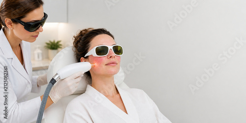 Dermatologist treating facial redness with laser therapy in a modern clinic. Rosacea, skin inflammation, and cosmetic care