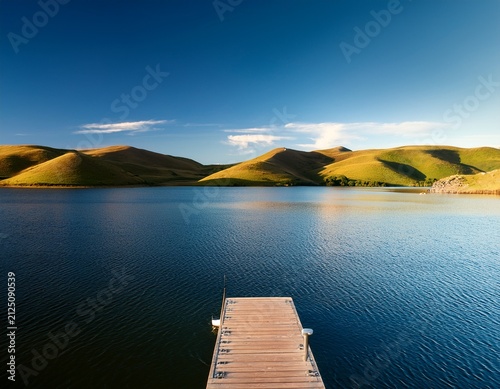 scenic lake landscape with moorage dock and rolling hills peaceful waterfront nature and outdoor travel destination