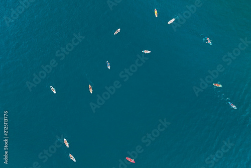 Canvas Print An aerial perspective shows several paddleboarders gliding smoothly on the deep blue ocean