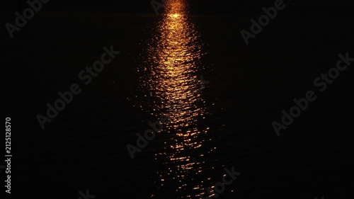 Night Lights Reflecting on Calm Ocean Water at Dusk with Beautiful Horizon, Orange Sky, Coastal Landscape and Evening Glow for Nature and Seascape Background Concept