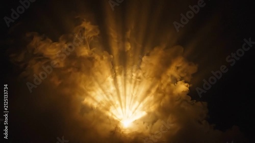 Bright light explosion with dramatic sunburst rays and thick smoke clouds against a dark background