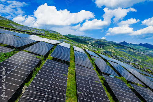 Aerial view of a large-scale solar farm with photovoltaic panels on green mountain slopes in Guizhou, China